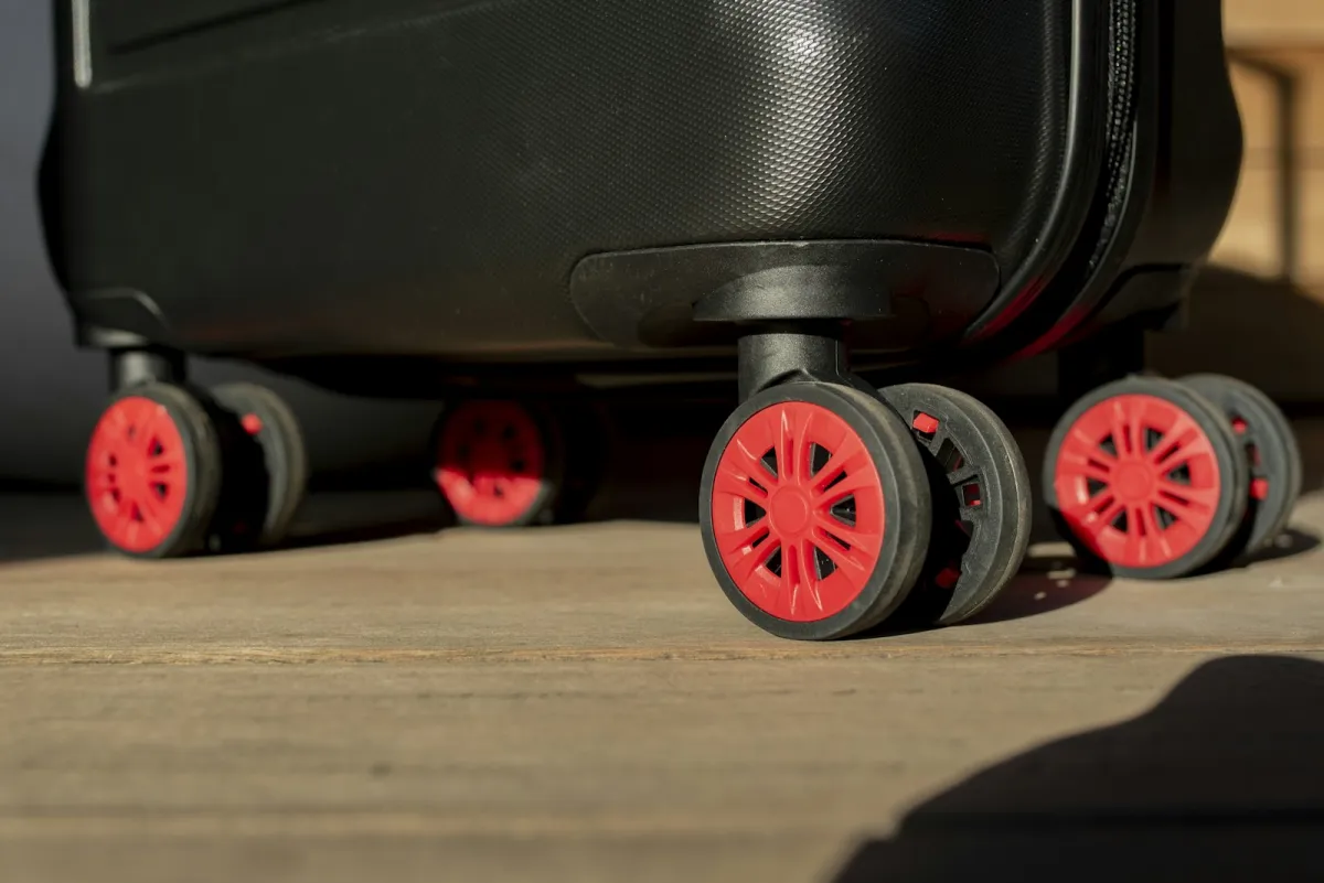 Close-up of carry-on suitcase wheels in warm light