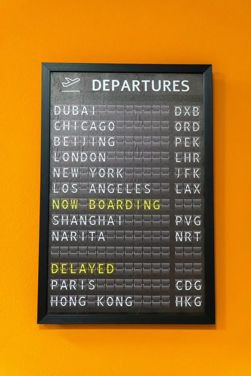 An airport departures board showing a delayed flight