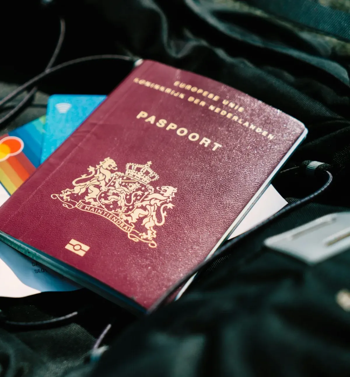 A passport resting on top of travel cards